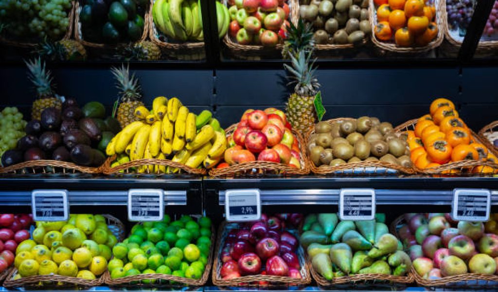 Fresh fruits in wicker baskets on shelf of supermarket